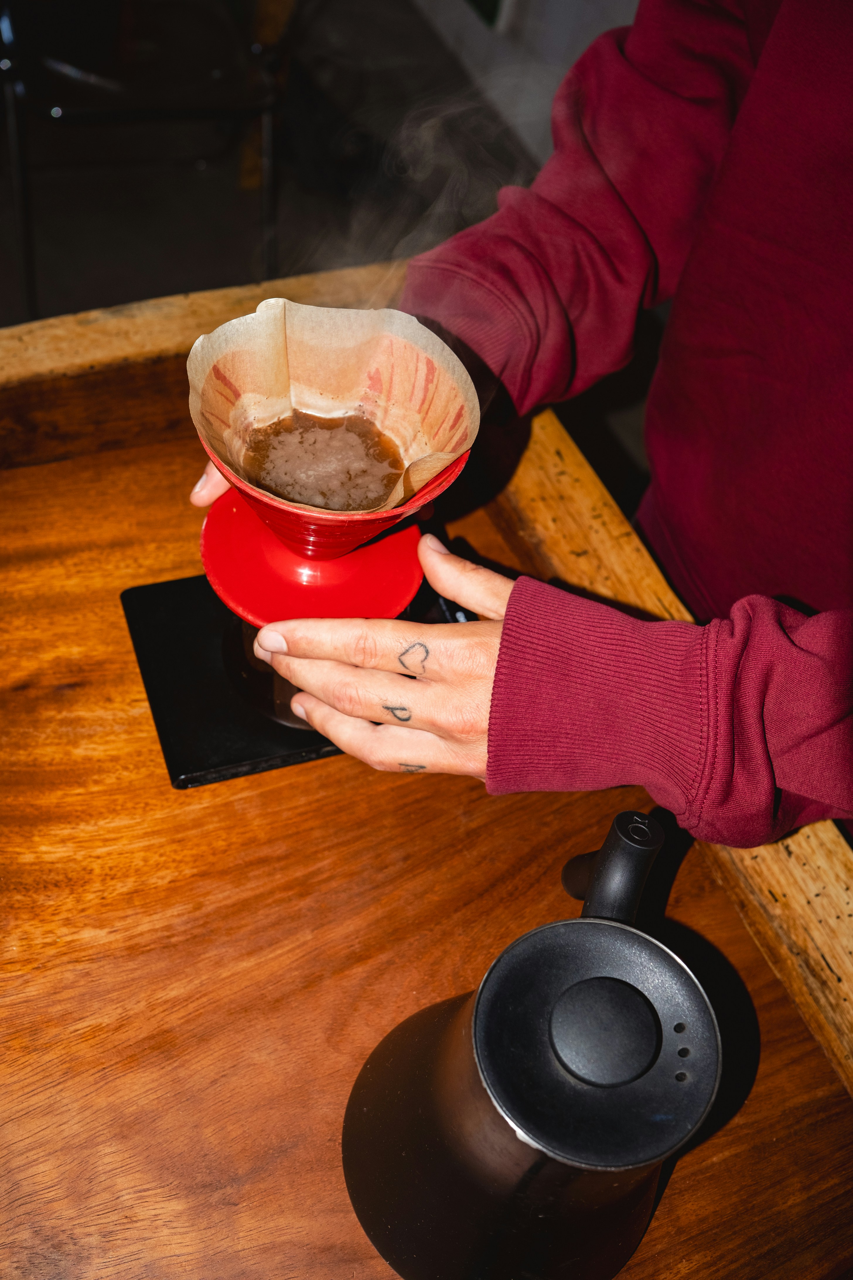 Coffee being prepared with a red pour-over brewer